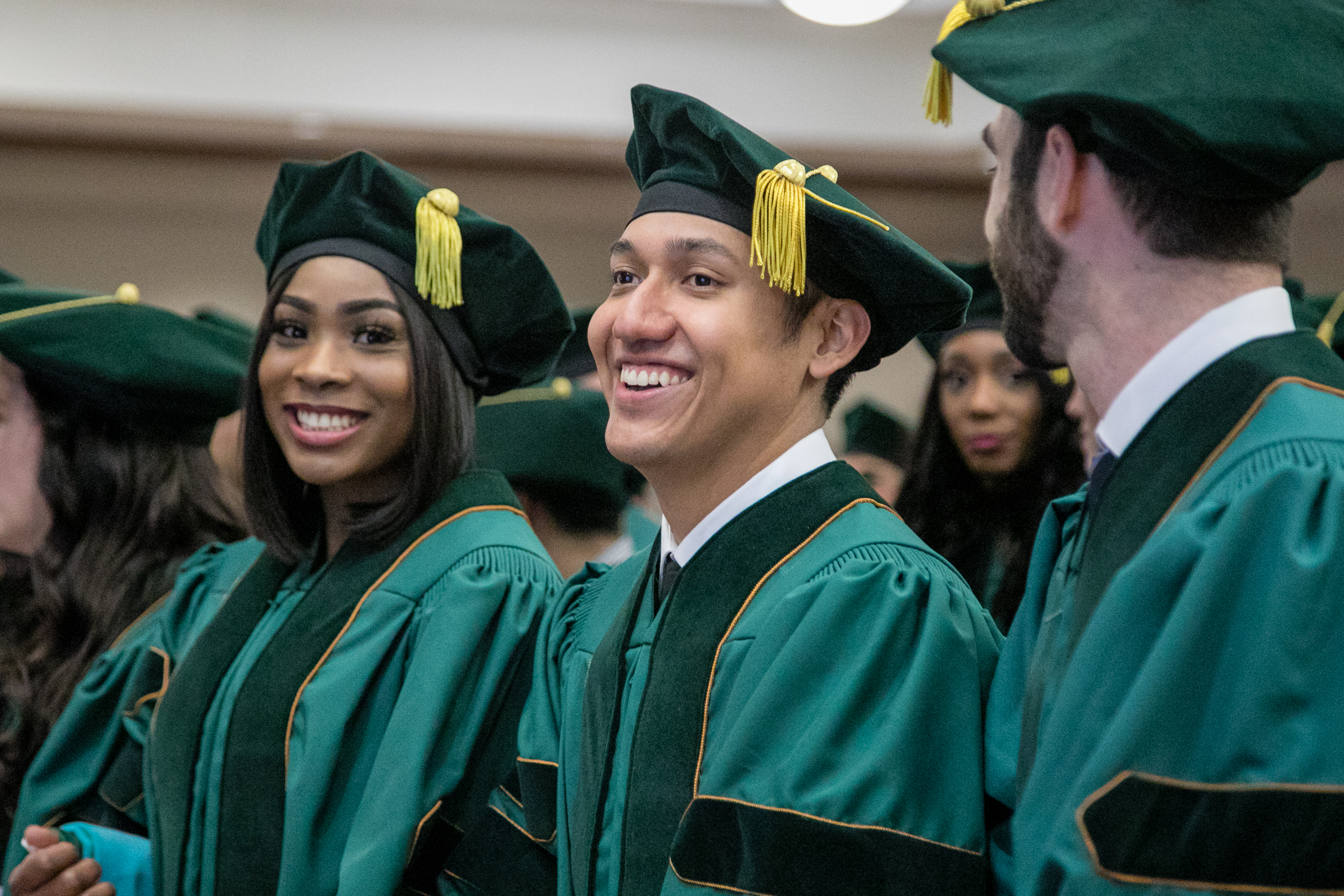 Doctor of Physical Therapy graduates smiling at hooding ceremony.