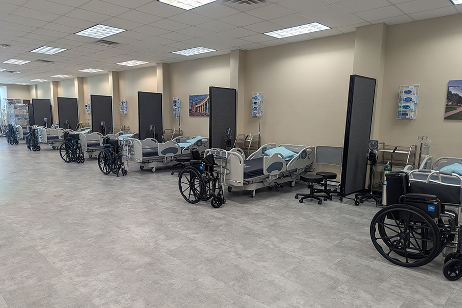 Rows of hospital beds and rehabilitation equipment in Student Life Center