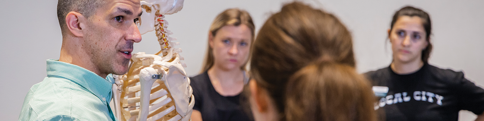 Faculty instructing students with skeleton