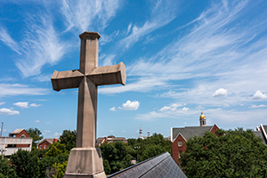 Image of a stone cross in front of the Baylor skyline