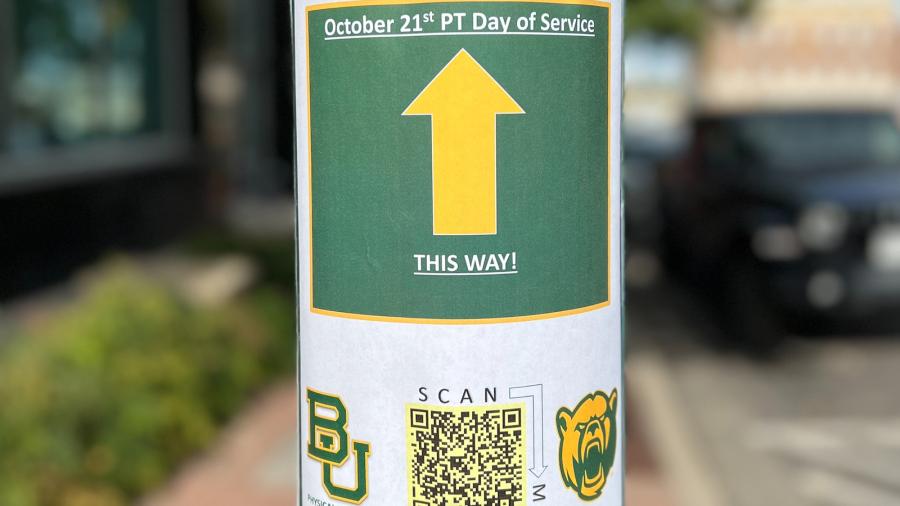 Sign on lampost indicates to walkers where to go for Baylor's Physical Therapy Day of Service.