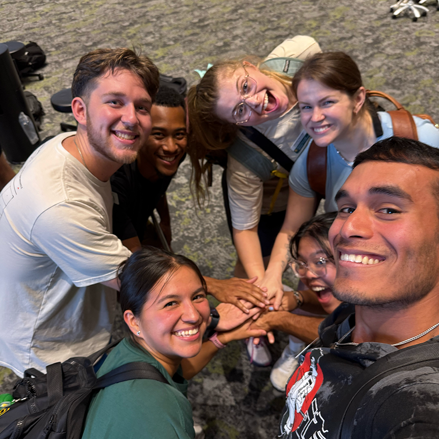 Selfie of several Baylor DPT students putting their hands together.